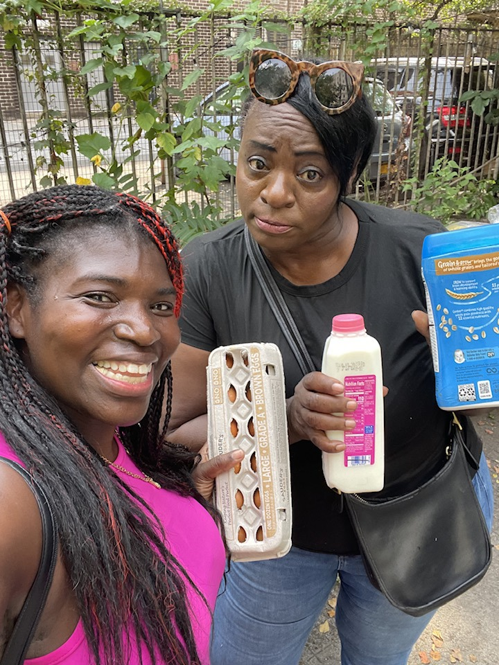 Volunteer selfie with a community member holding eggs, milk, and cereal